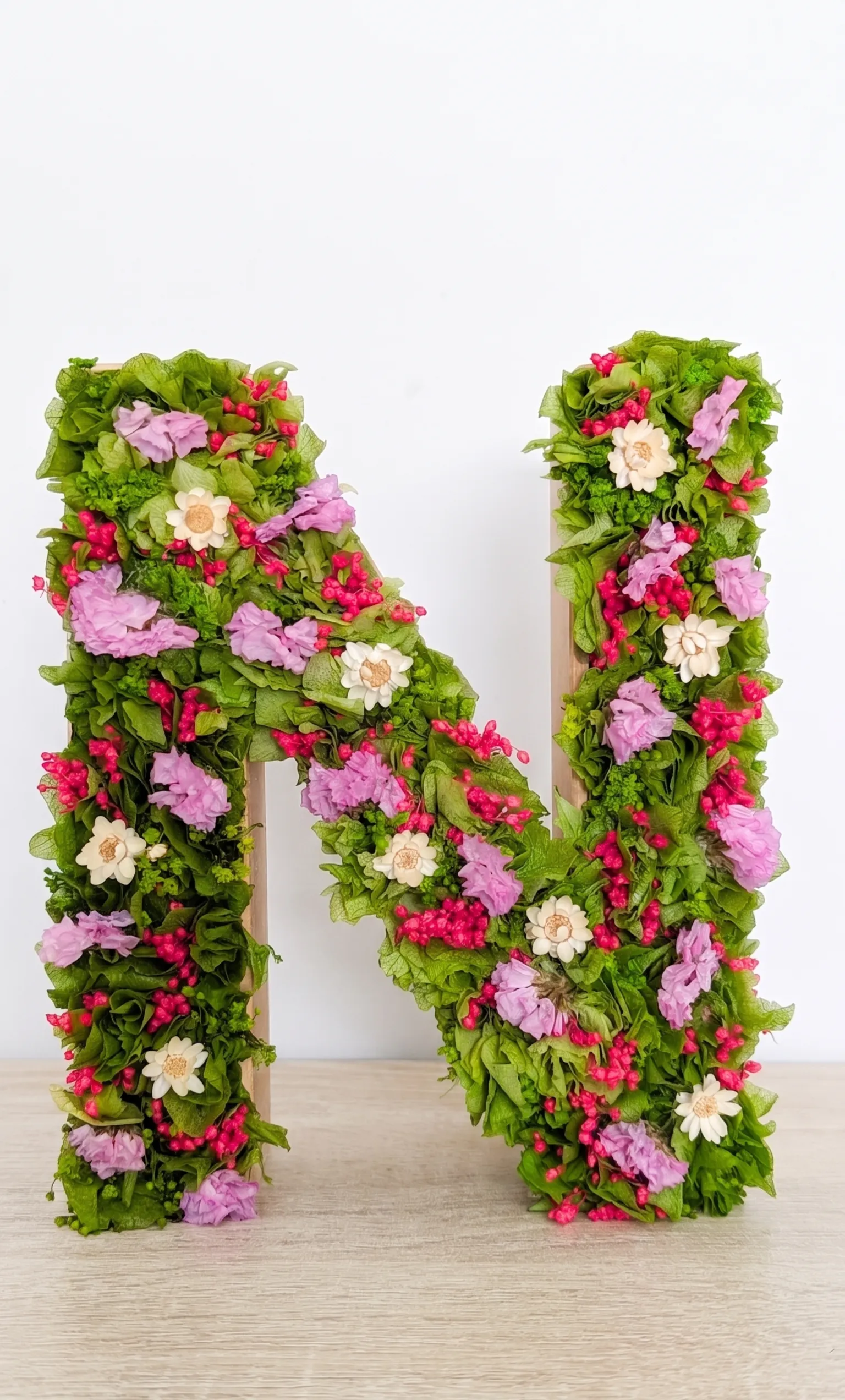 Inicial N de madera decorada a mano con arreglo floral de flores preservadas y secas en tonos suaves y naturales